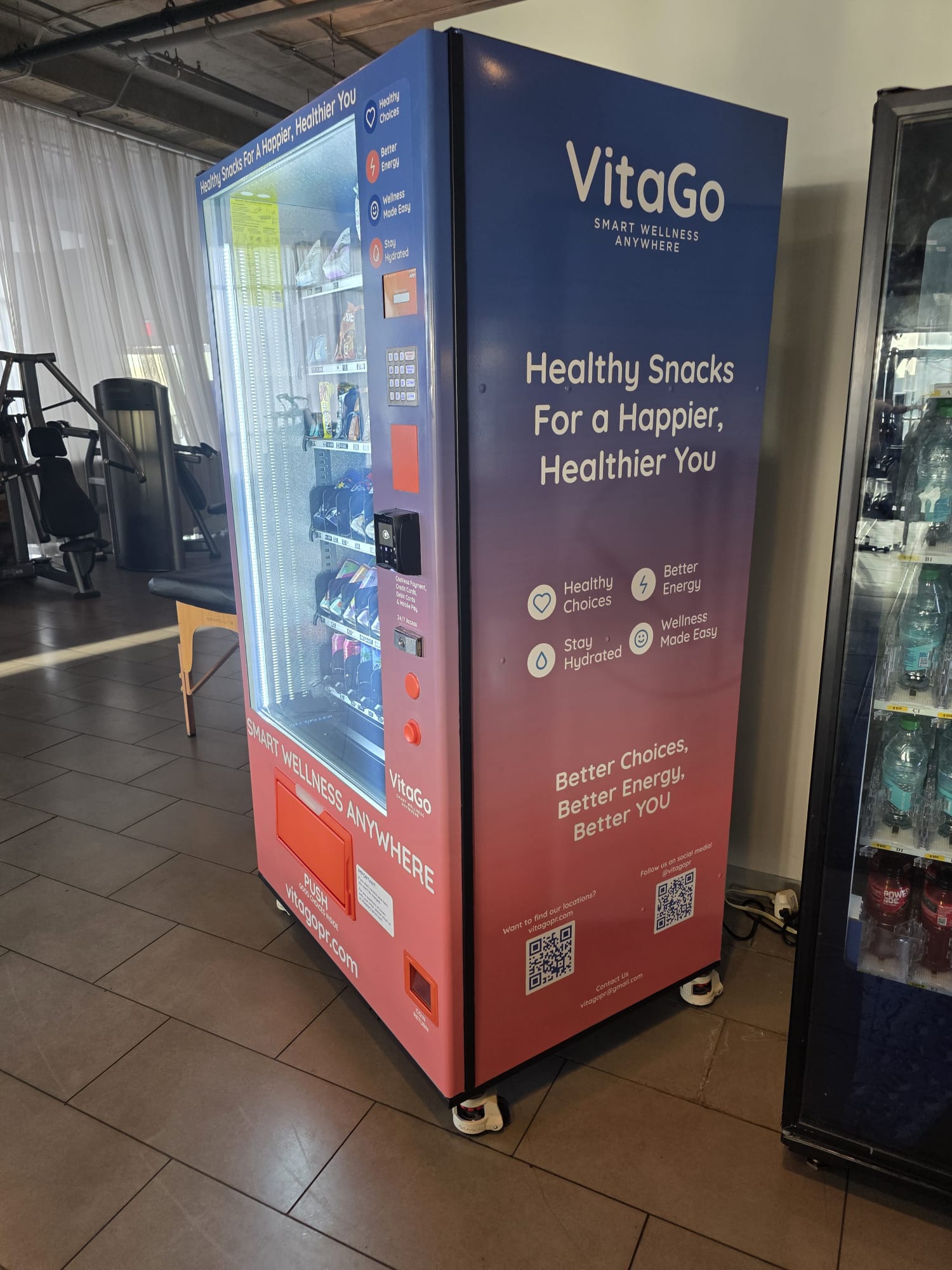 VitaGo healthy vending machine installed at a fitness center next to a beverage cooler