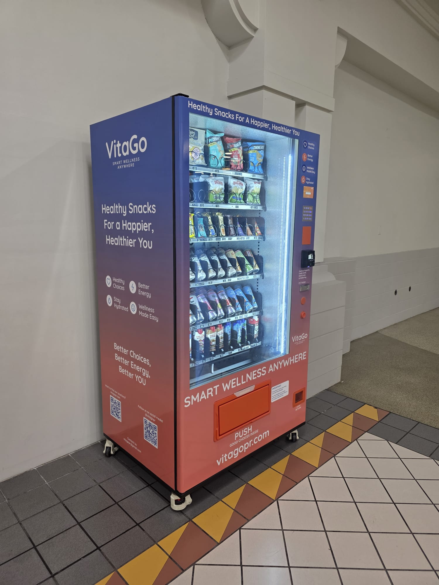 VitaGo smart vending machine — front view with healthy snacks behind the glass and a blue-to-orange gradient wrap